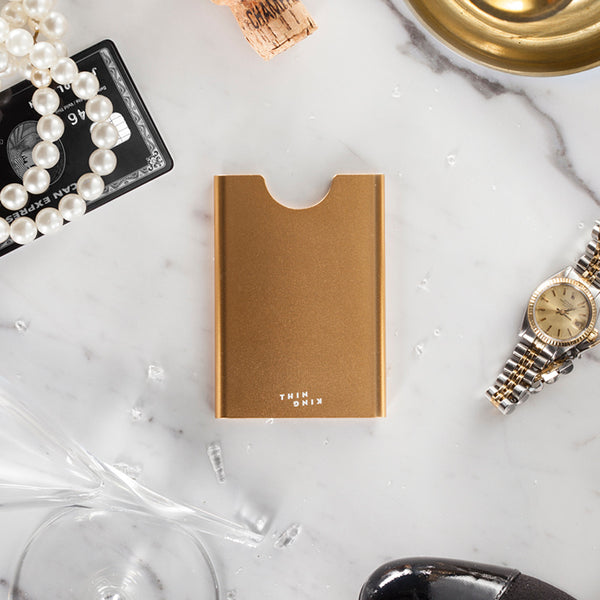 Champagne colour Thin King credit card case  with a black Amex