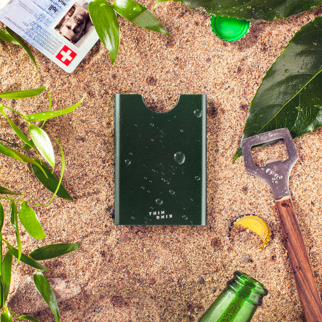 Bullitt green Thin King credit card case on a sandy beach 
